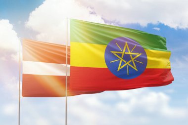 Sunny blue sky and flags of ethiopia and latvia