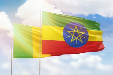 Sunny blue sky and flags of ethiopia and mali