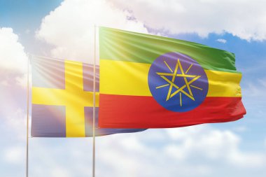 Sunny blue sky and flags of ethiopia and sweden