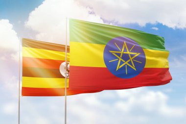Sunny blue sky and flags of ethiopia and uganda