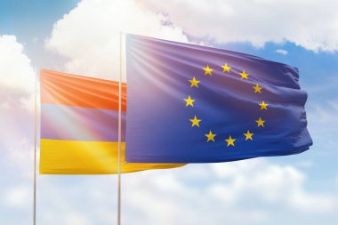 Sunny blue sky and flags of european union and armenia