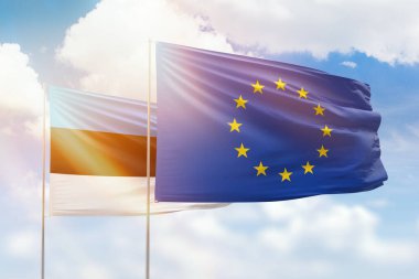 Sunny blue sky and flags of european union and estonia