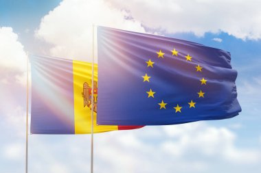 Sunny blue sky and flags of european union and moldova