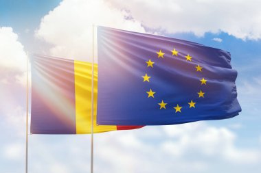 Sunny blue sky and flags of european union and romania