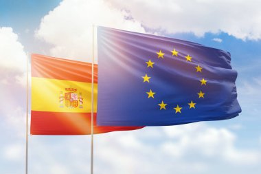 Sunny blue sky and flags of european union and spain