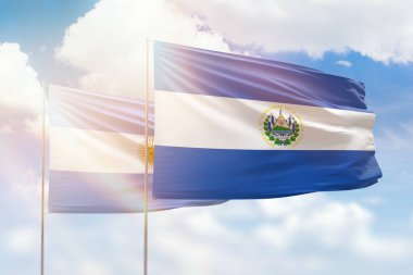 Sunny blue sky and flags of el salvador and argentina