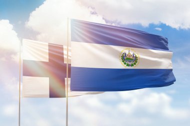 Sunny blue sky and flags of el salvador and finland