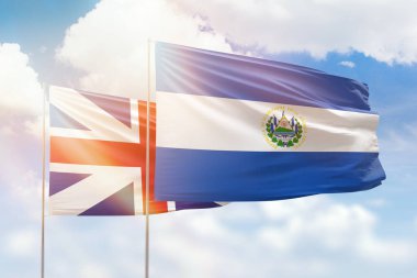 Sunny blue sky and flags of el salvador and great britain