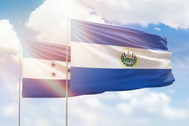 Sunny blue sky and flags of el salvador and honduras