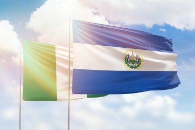 Sunny blue sky and flags of el salvador and nigeria