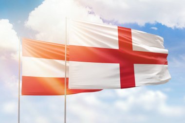Sunny blue sky and flags of england and austria