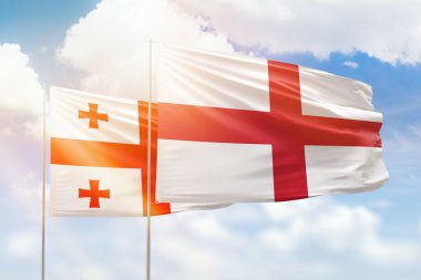 Sunny blue sky and flags of england and georgia