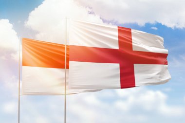 Sunny blue sky and flags of england and indonesia