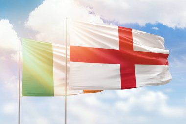 Sunny blue sky and flags of england and ireland