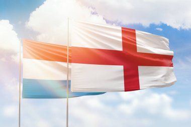 Sunny blue sky and flags of england and luxembourg