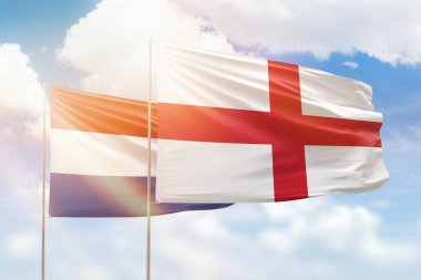 Sunny blue sky and flags of england and netherlands