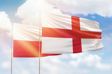 Sunny blue sky and flags of england and poland