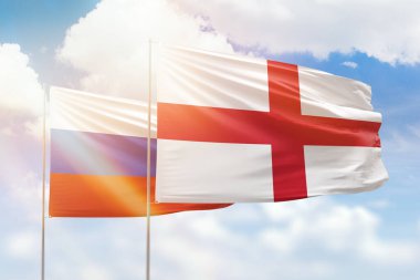Sunny blue sky and flags of england and russia