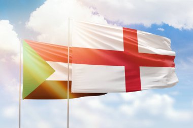 Sunny blue sky and flags of england and sudan