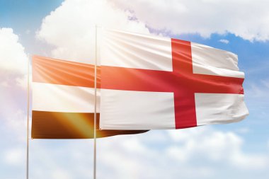 Sunny blue sky and flags of england and yemen
