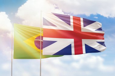 Sunny blue sky and flags of great britain and brazil