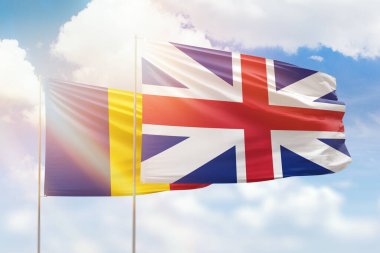 Sunny blue sky and flags of great britain and romania