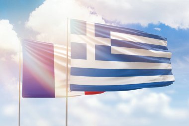Sunny blue sky and flags of greece and france