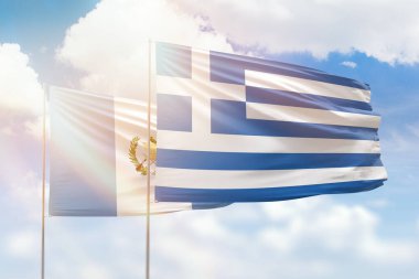 Sunny blue sky and flags of greece and guatemala