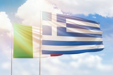 Sunny blue sky and flags of greece and italy