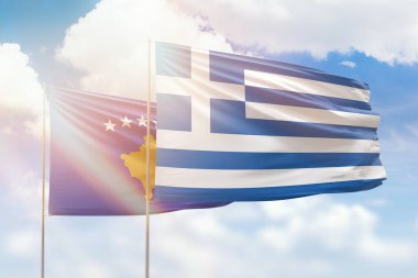 Sunny blue sky and flags of greece and kosovo