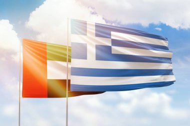 Sunny blue sky and flags of greece and uae
