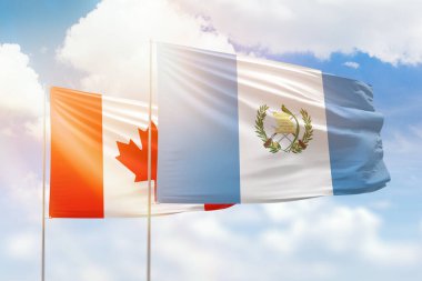 Sunny blue sky and flags of guatemala and canada