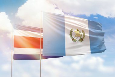 Sunny blue sky and flags of guatemala and costa rica