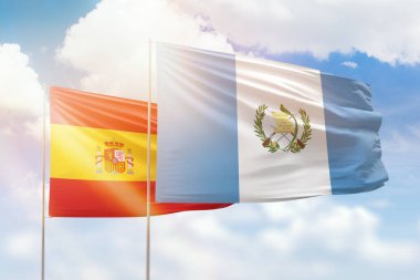 Sunny blue sky and flags of guatemala and spain