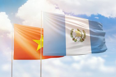 Sunny blue sky and flags of guatemala and vietnam