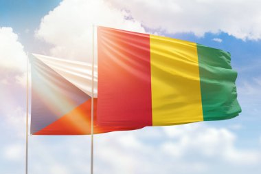 Sunny blue sky and flags of guinea and czechia