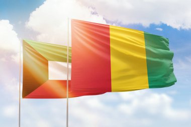 Sunny blue sky and flags of guinea and kuwait