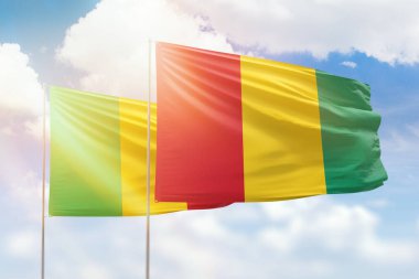 Sunny blue sky and flags of guinea and mali