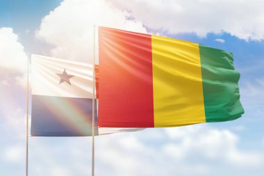 Sunny blue sky and flags of guinea and panama