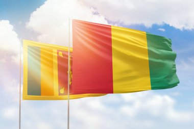 Sunny blue sky and flags of guinea and sri lanka