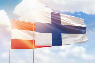 Sunny blue sky and flags of finland and austria
