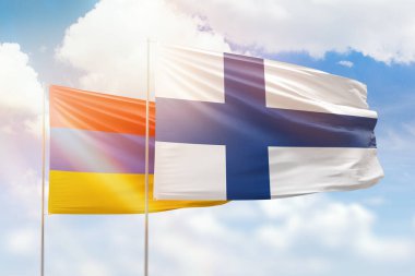 Sunny blue sky and flags of finland and armenia