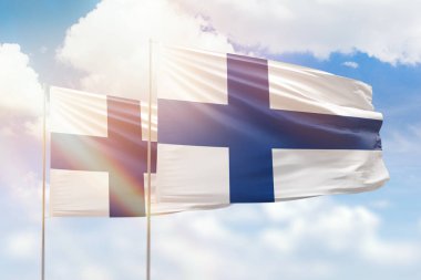 Sunny blue sky and flags of finland and finland