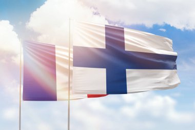 Sunny blue sky and flags of finland and france