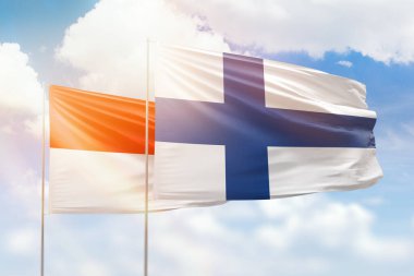 Sunny blue sky and flags of finland and indonesia