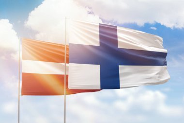 Sunny blue sky and flags of finland and latvia