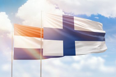Sunny blue sky and flags of finland and netherlands