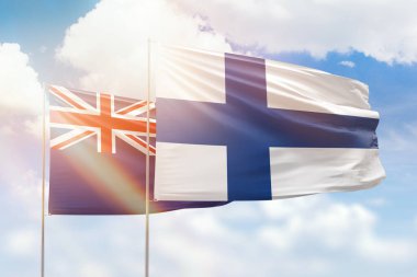Sunny blue sky and flags of finland and new zealand