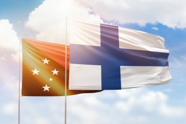 Sunny blue sky and flags of finland and papua new guinea
