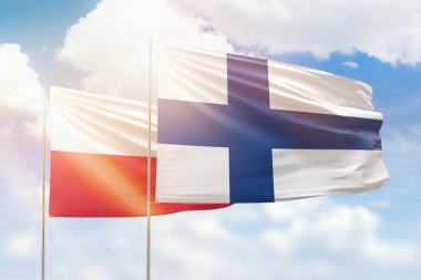 Sunny blue sky and flags of finland and poland